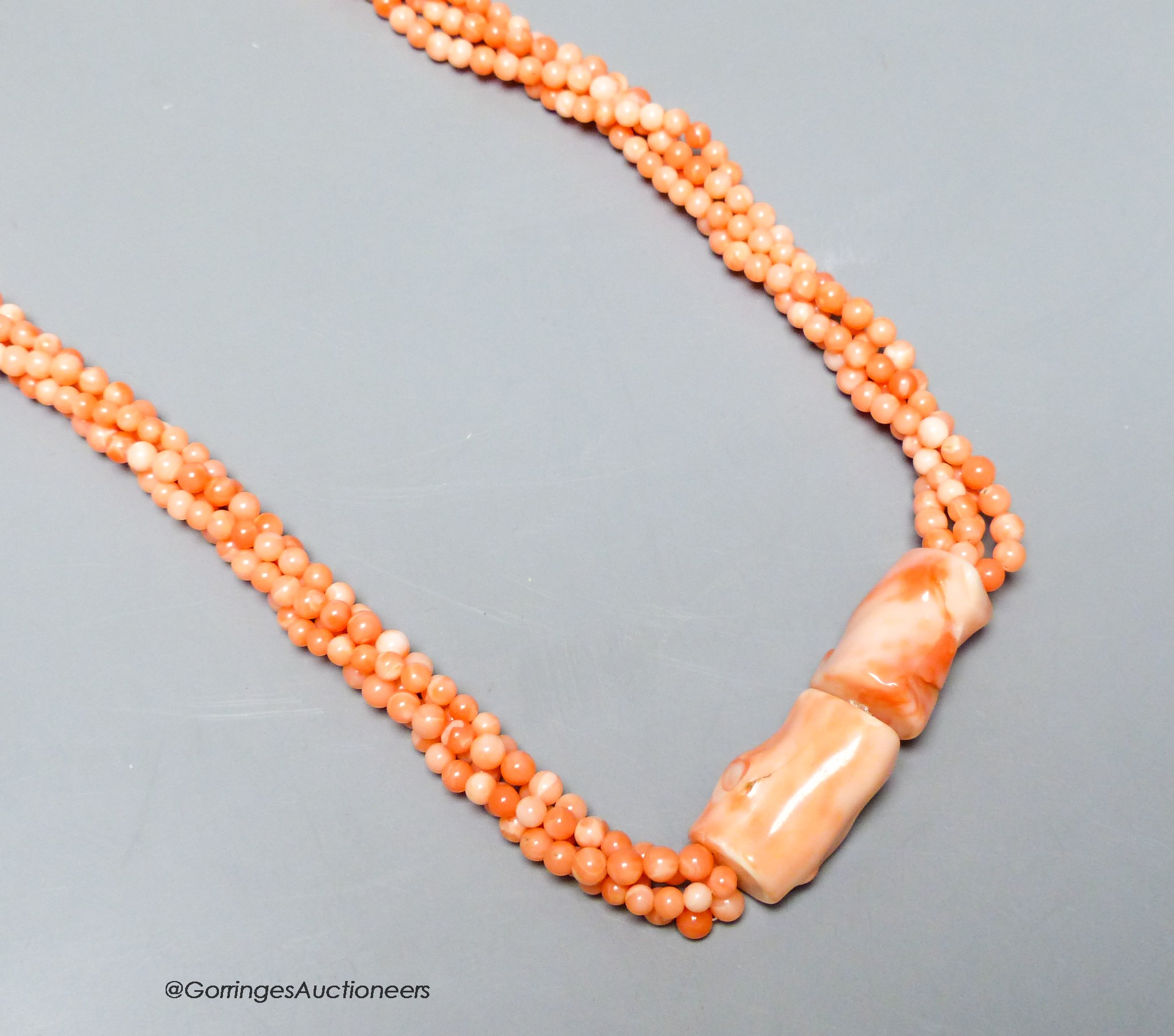 A modern twisted quadruple strand coral bead necklace, 78cm.